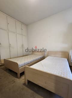 Two single beds and one makeup stand with mirror and chair