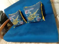 blue sofa with a tissu warde with two pillows