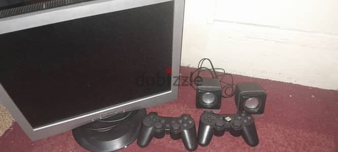 Computer screen with computer speakers and PlayStation controller USP