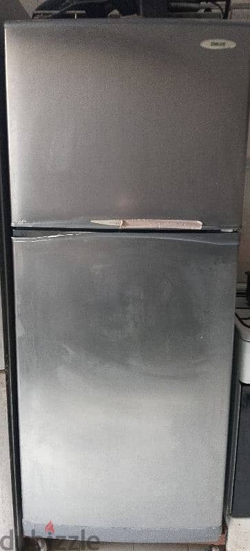 two refrigerators with a corner couch and an oven 0