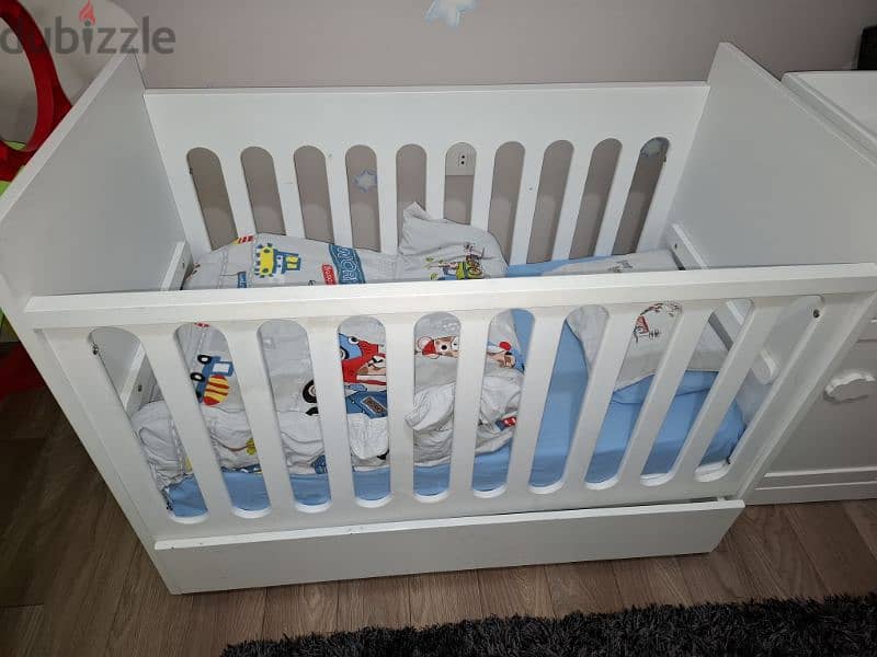 Bed, white baby dresser with changing table, and wardrobe. 1