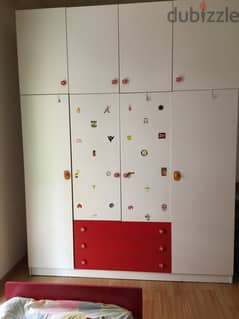 Closet for clothes with red bed for child bedroom.